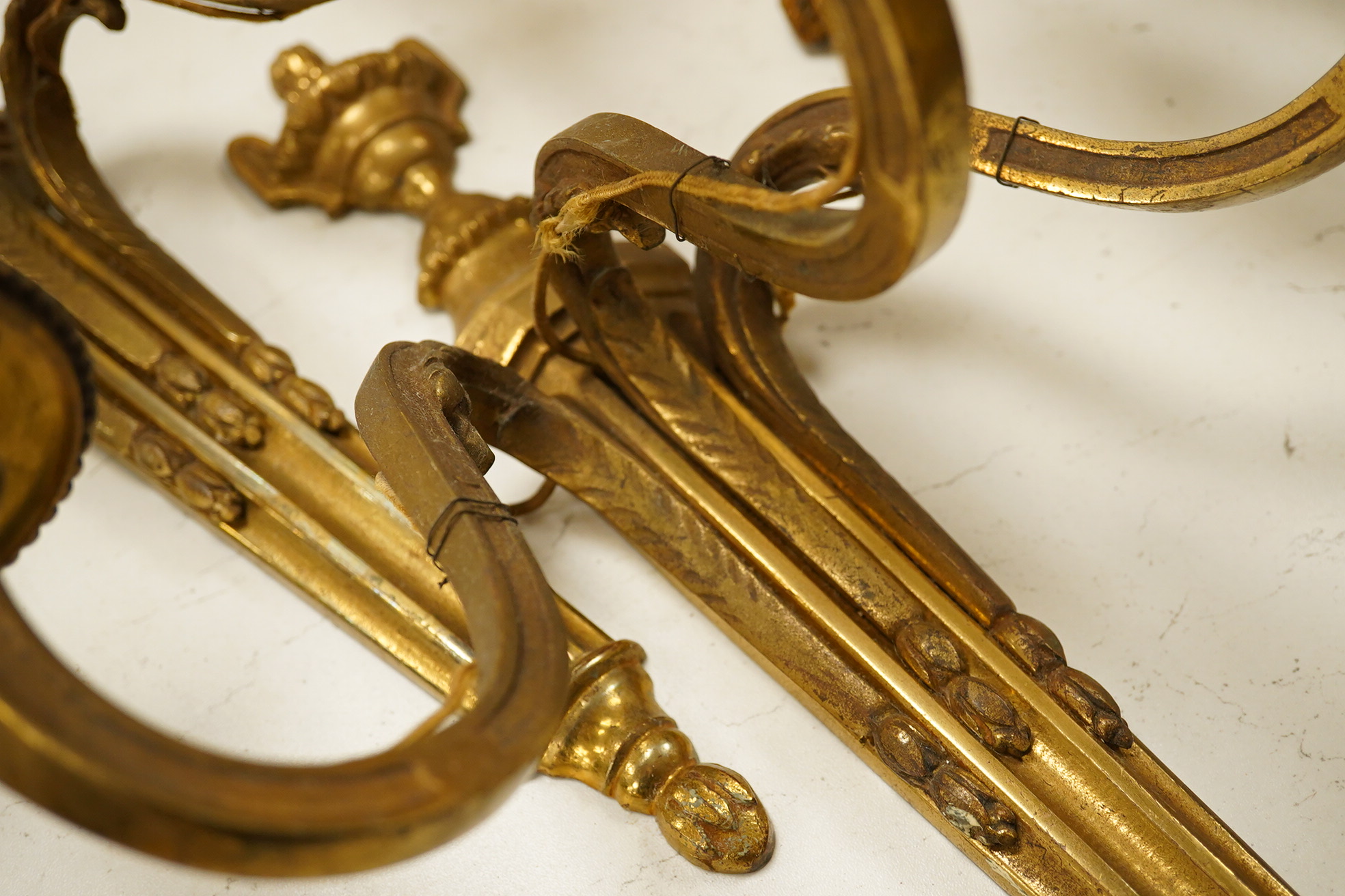 An ormolu ceiling light, a pair of three branch sconces and two pairs of two light sconces, largest 38cm high. Condition - variable